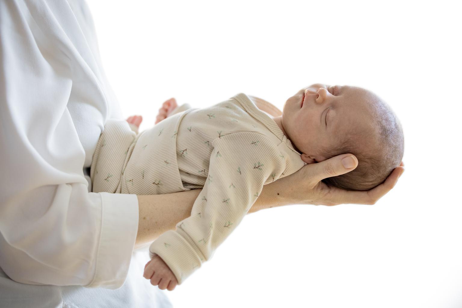 Ein Baby das in den Armen gehalten wird.